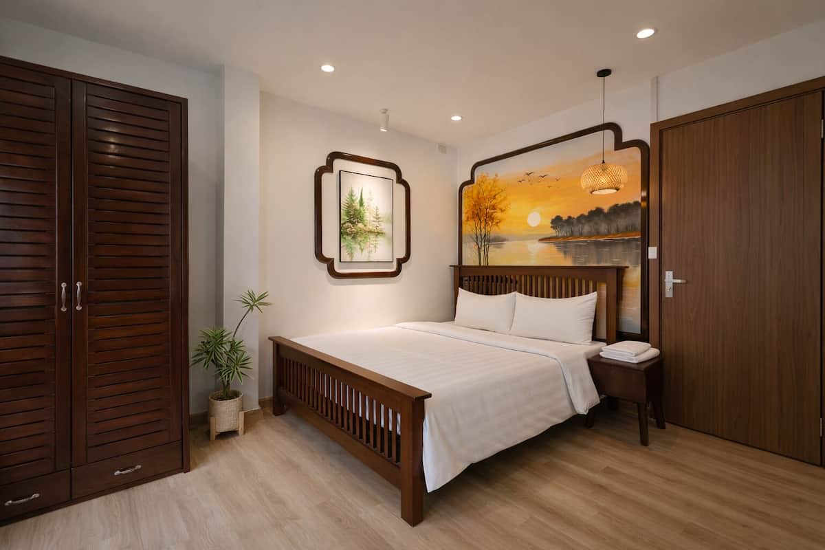 Une chambre à coucher avec un lit, une armoire en bois et un tableau accroché au mur.