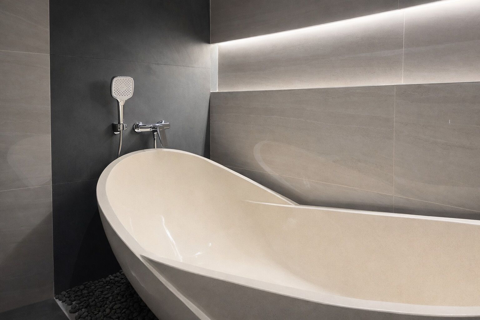 A modern bathtub with a sleek design, a handheld showerhead, and a wall-mounted faucet.