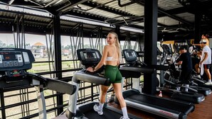A gym with treadmills, a control panel, and a view of the outdoors. - Rendezvous Wellness & Resort (Ubud)