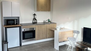 A modern kitchen with a microwave, oven, sink, and wooden cabinets.