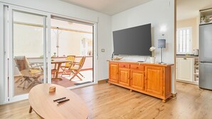 Ett modernt kök med ett träskåp, ett matbord och en skjutdörr i glas som leder ut till ett utomhusområde.
