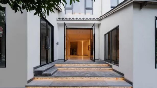 Un bâtiment moderne doté d’une grande entrée centrale qui donne sur un espace intérieur.