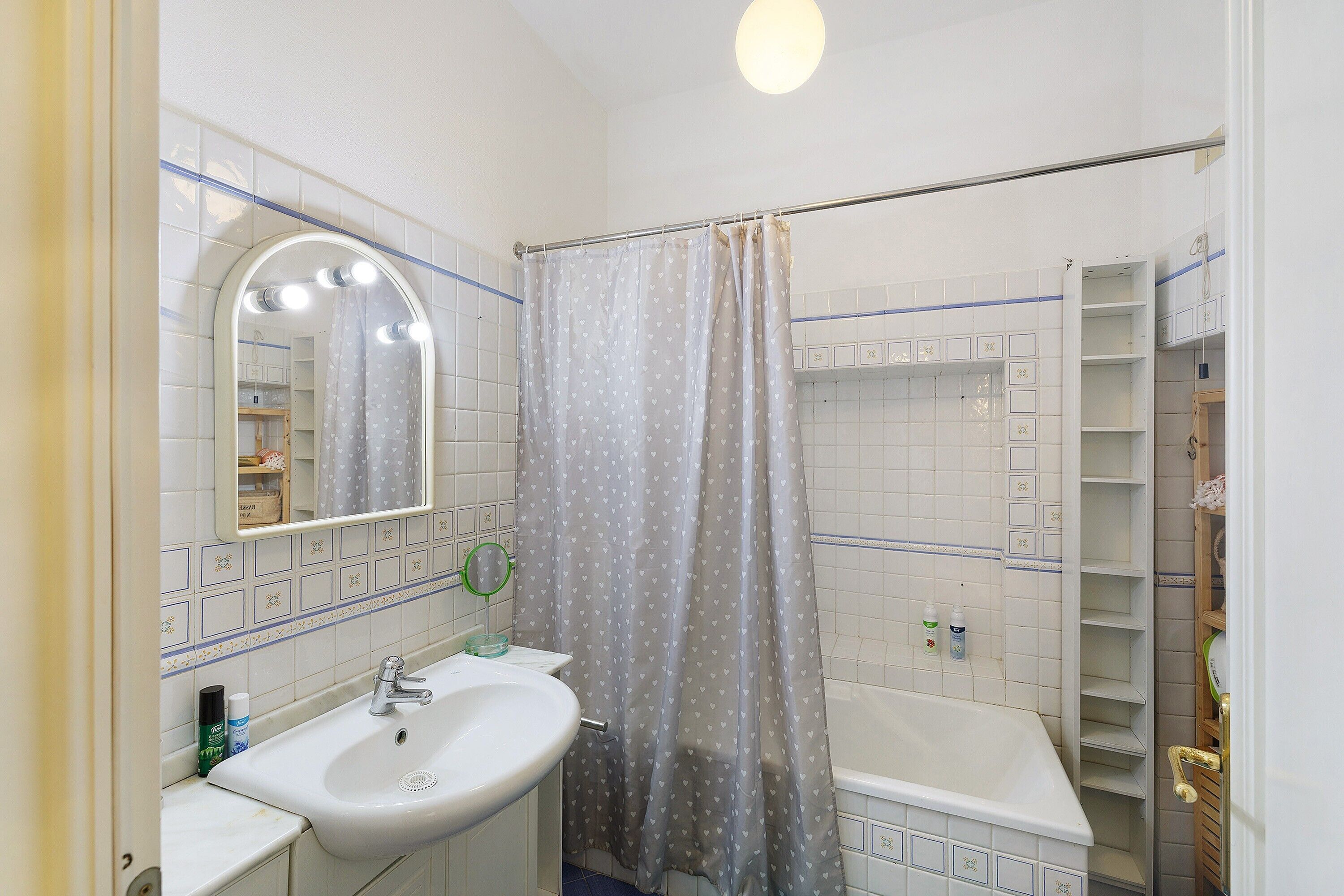 Ein Badezimmer mit Waschbecken, Spiegel, Duschvorhang und Badewanne.