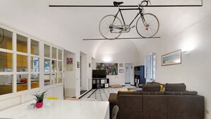 Un intérieur moderne comprenant un coin repas, un canapé et un vélo fixé au plafond.
