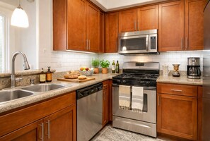 A modern kitchen with wooden cabinets, stainless steel appliances, a granite countertop, and a built-in dishwasher. - Cozy 1BA Marina Del Rey Venice (Marina del Rey)