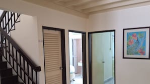 A hallway with a marble floor, a staircase with black railings, and a door leading to another room. - Spacious 4-bedroom house in gorgeous Subang Jaya with AC (Subang Jaya)