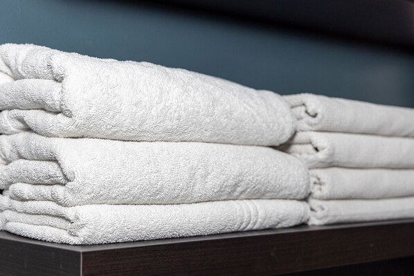 Une pile de serviettes blanches sur une surface en bois foncé.