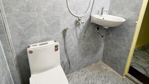 A small bathroom with a toilet, a shower, and a sink. - Para Hostel Koh Rong (Koh Rong)