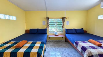 A hotel room with two beds, a window with curtains, a small table with a tray, and a tiled floor.