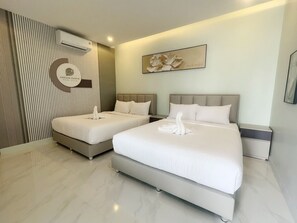 Une chambre d’hôtel avec deux lits, un climatiseur fixé au mur, un élément décoratif mural et un panneau indiquant qu’elle offre une vue sur la piscine.