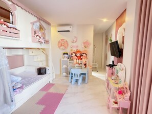 A child's bedroom with bunk beds, a desk, and a vanity with mirrors.