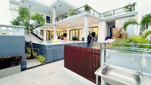 A modern building with a covered outdoor area, a staircase, and a sink.