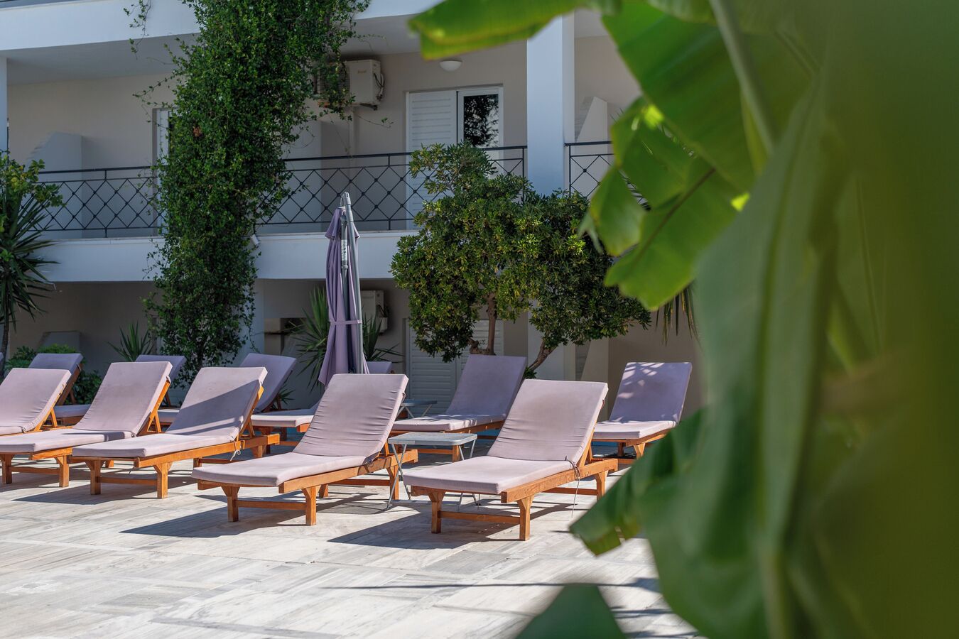 A pool area with sun loungers and a covered seating area.