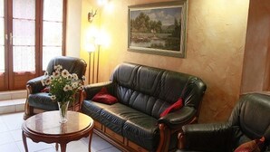 Un saló amb un sofà, butaques, una taula de centre, una làmpada i un quadre a la paret.