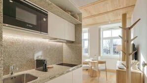 Eine moderne Küche mit einer Bosch-Mikrowelle, einer Arbeitsplatte aus Granit und einem Essbereich mit rundem Tisch und Stühlen.