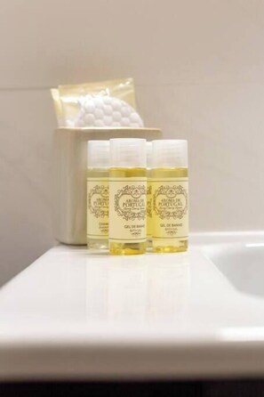 Three bottles of bath gel on a white surface, with a white container in the background. - Bonjardim Downtown Studio by DA'HOME (Porto)