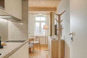Una cocina moderna con encimeras de granito, estufa integrada y comedor con mesa y sillas.