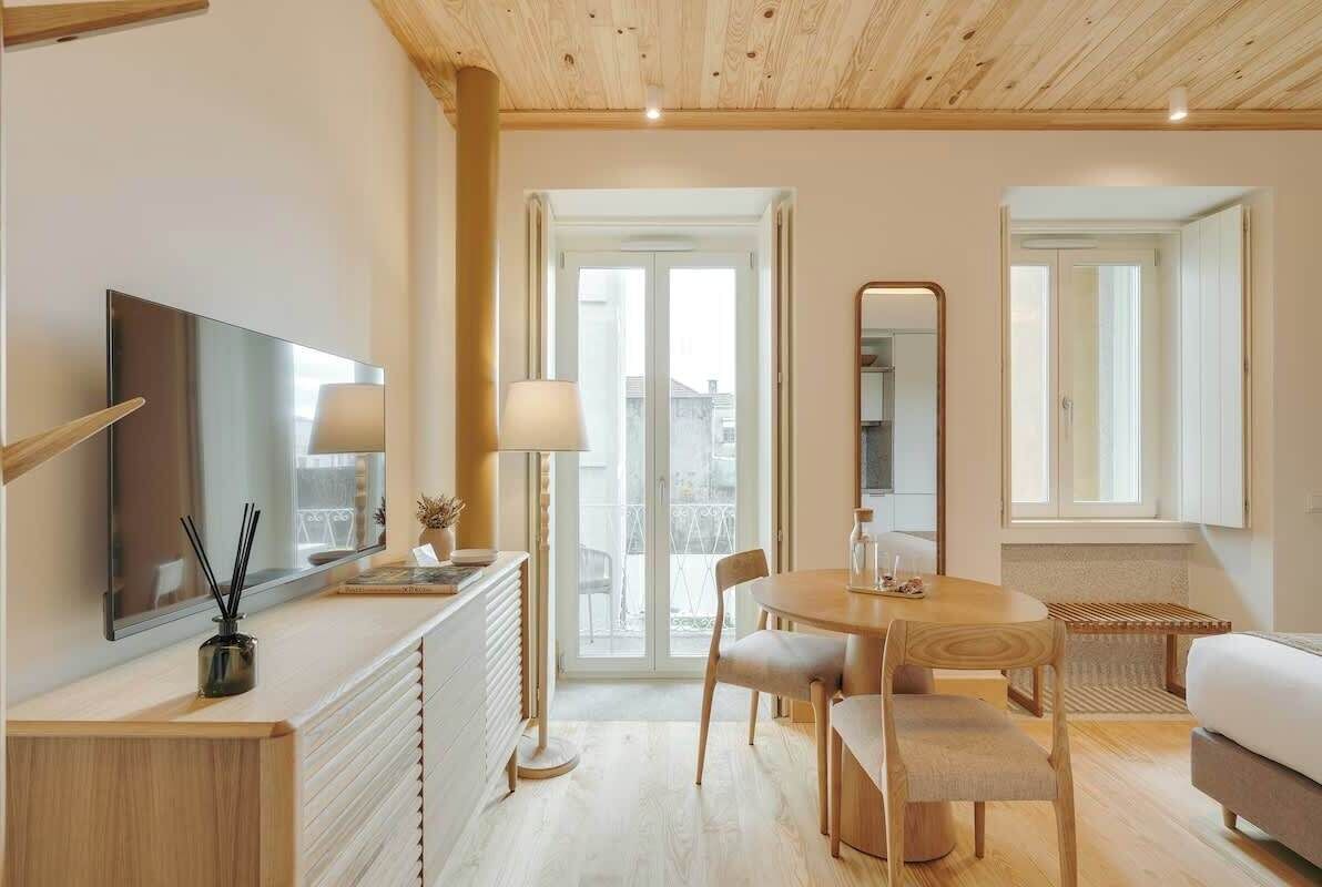 Un salon moderne comprenant un téléviseur, une table à manger avec des chaises, un canapé et un grand miroir.