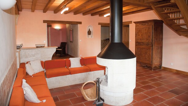 A cozy living area with a fireplace, wooden beams, and a stone fireplace surround. - Gite du Pigeonnier and its tower with terraces and garden (Castelnau-sur-l'Auvignon)