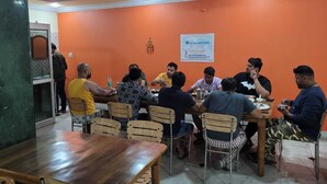 A restaurant with orange walls and wooden furniture. - New Samrat Hotel And Restaurant (Srinagar)
