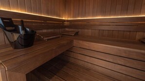 Uma sauna com bancos de madeira e uma cadeira de sauna preta.