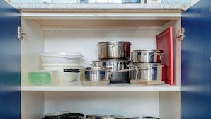 A kitchen with a microwave, pots, and a red door. - Perfect for Teams & Families: 3-Bedroom Flat, 7 Guests, Balcony, Close to Centre (Bratislava)