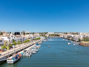 A marina with boats docked along a waterfront, surrounded by buildings and a clear sky. - Olea Green Studio 1, Tavira, Algarve (Querença)
