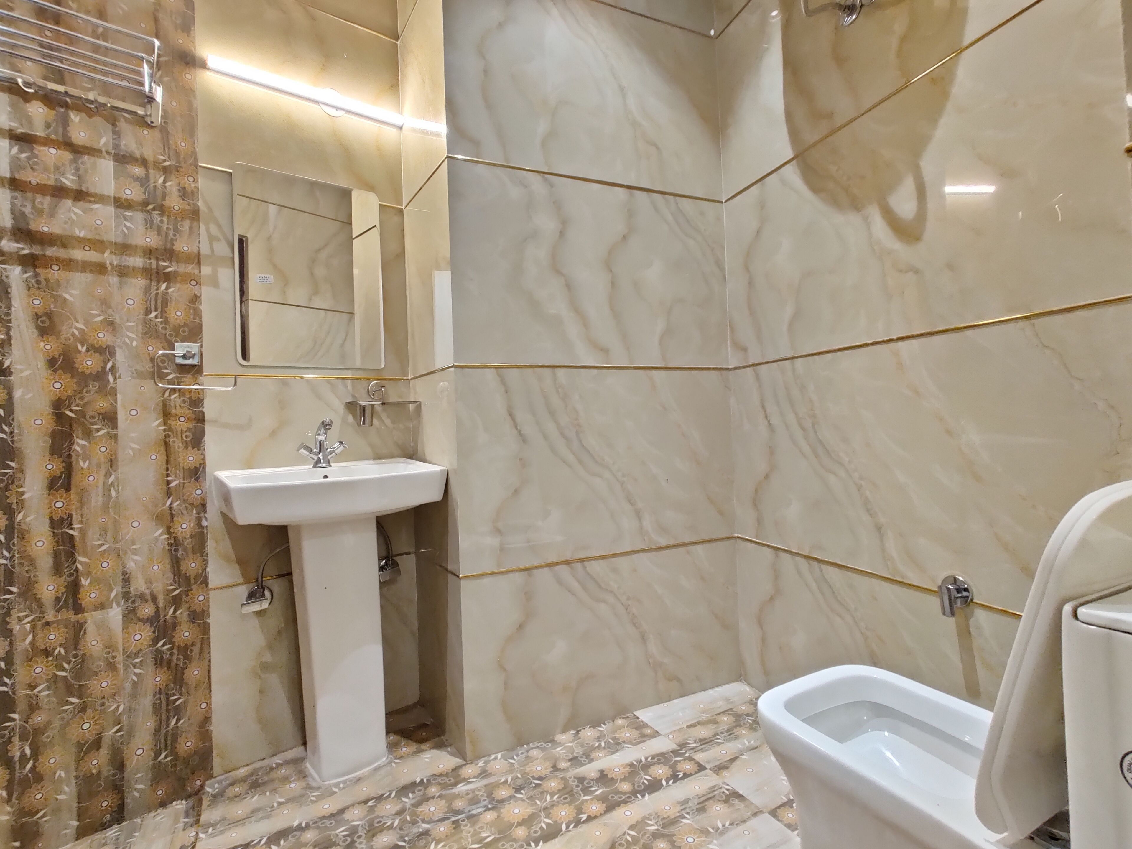 Un baño con un lavamanos blanco, un inodoro y una zona de ducha.