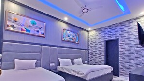A modern bedroom with two beds, a stone accent wall, and artwork. - Taj Pride Inn (Amritsar)