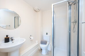 A bathroom with a sink, toilet, and shower. - 2 bed flat with parking (West Sussex)