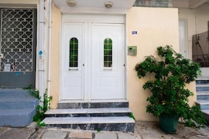 A building entrance with two white doors, a small potted plant, and a number 16 sign. - Spacious & Modern Retreat with Sun Terrace in Neos Kosmos, Athens (Athina)