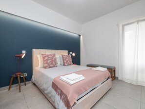 A modern bedroom with a bed, bedside tables, and a bench. - Olea Black Studio 2, Tavira, Algarve (Querença)