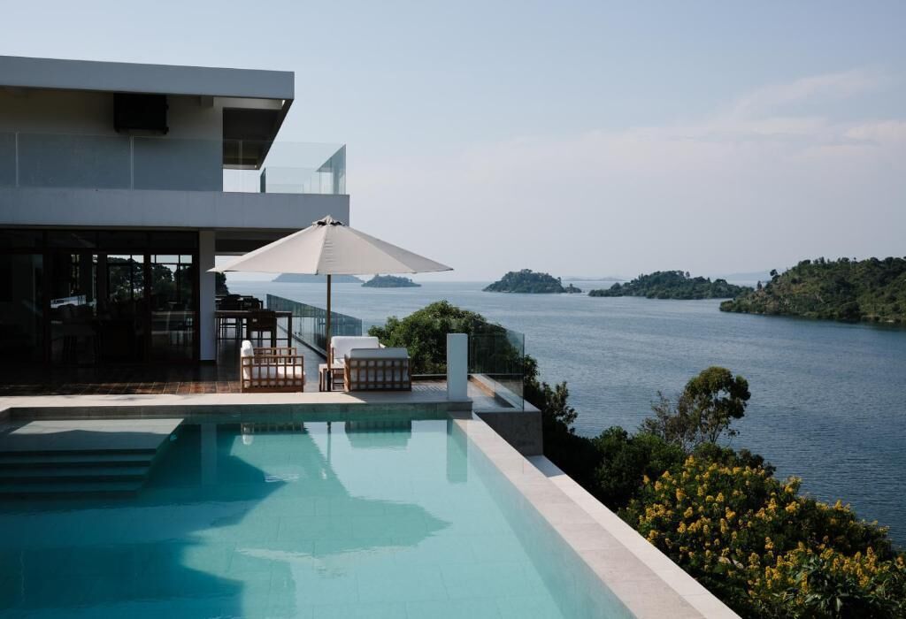 A modern pool area with a view of the sea and islands.