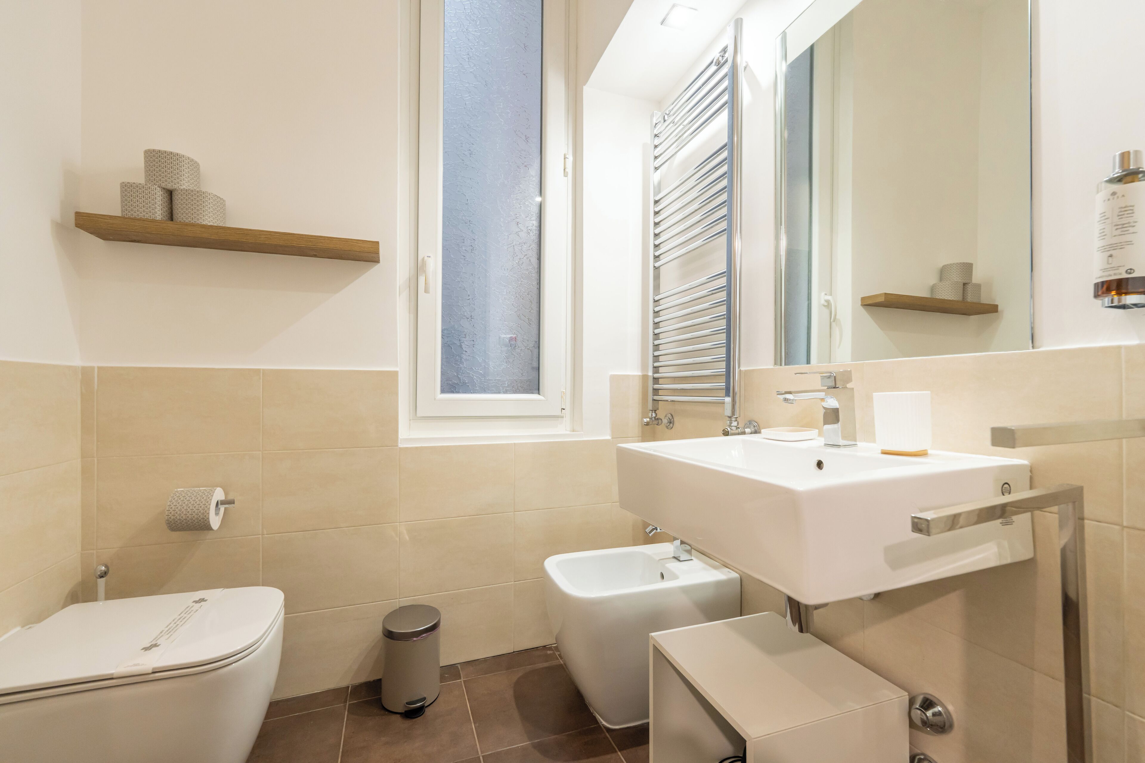 A modern bathroom with a toilet, bidet, and sink.