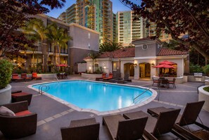 A swimming pool with lounge chairs and a bar area, surrounded by tall buildings. - Sunny Marina Del Rey 1BA Getaway (Marina del Rey)