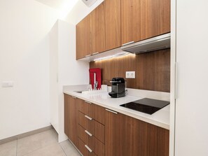 Uma cozinha moderna com armários de madeira, bancada e coifa embutida.
