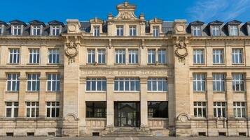 Un edificio grande e histórico con fachada simétrica, múltiples ventanas y una entrada central con un cartel que dice 'TELEGRAPHS POSTES TELEPHONES'.