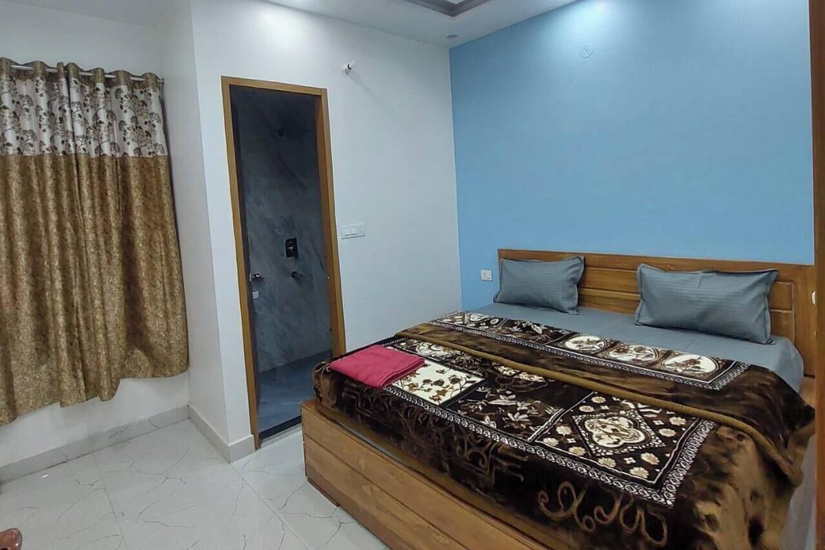 A bedroom with a bed, a door, and a ceiling light.