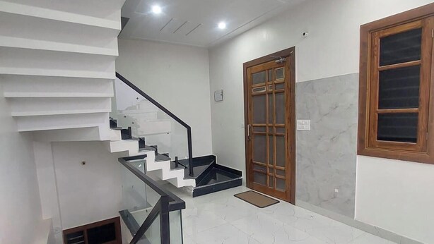 A modern interior with a staircase, a wooden door, and a window. - Himalayan View stay Shehar wala ghar (Dehradun)