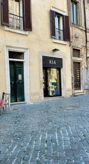 Ein Gebäude mit einer Schaufensterfront mit der Aufschrift "CLK" und einer grünen Tür mit einem Schild.