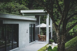 Una casa moderna con un patio, una mesa de comedor y sillas.