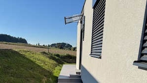 A modern building with a concrete pathway leading to a door with a window.