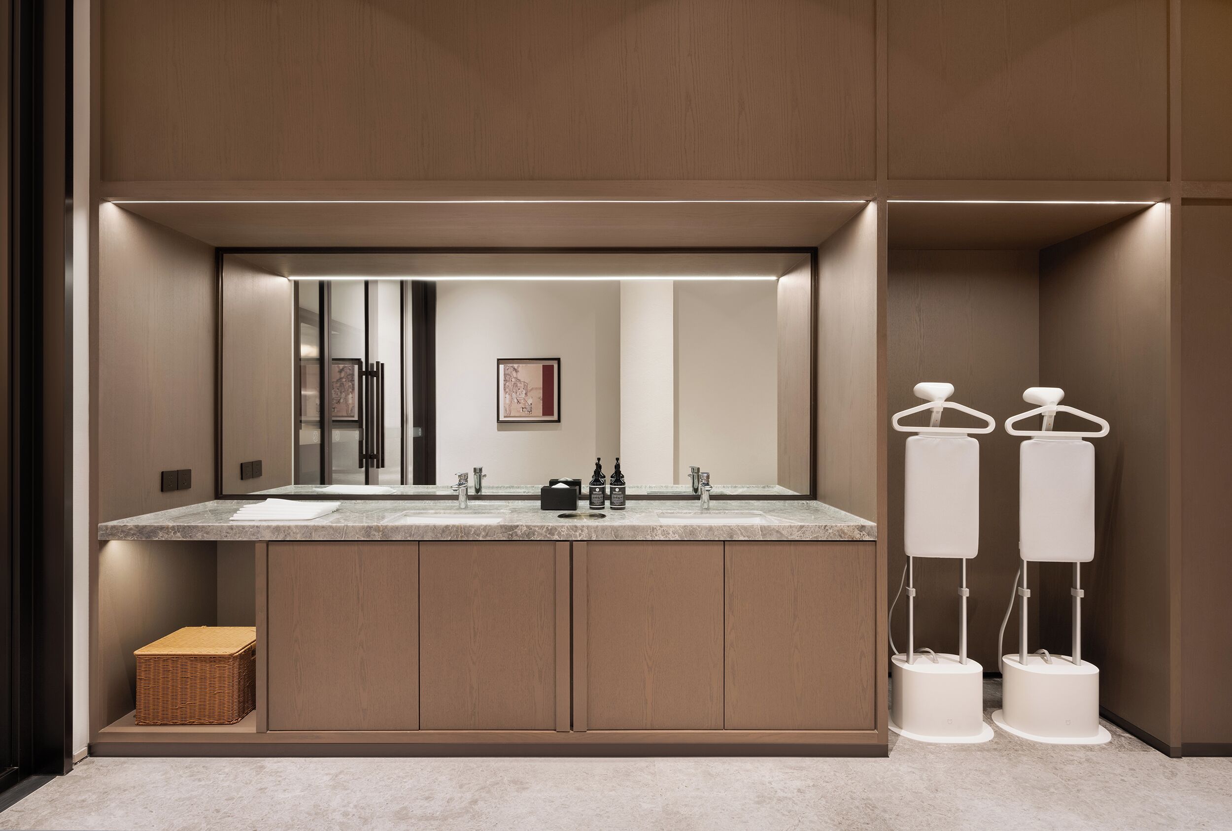 Une salle de bain moderne avec un grand miroir, deux lavabos et un porte-serviettes.