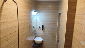 Ein modernes Badezimmer mit einer Duschkabine, einem Waschbecken und einem Spiegel.