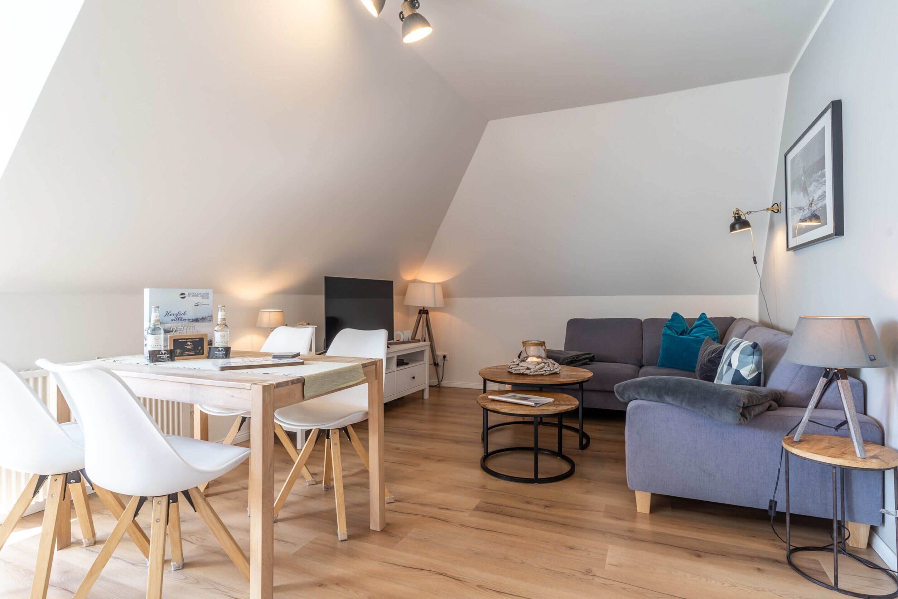 A modern loft apartment with a dining area, a sofa, and a small table.