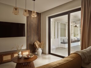 Ein modernes Wohnzimmer mit großem Fernseher, einer Wand aus Holzpaneelen und einer Schiebeglastür, die auf einen Balkon führt.