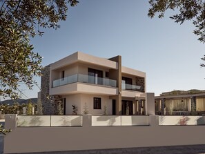 Ein modernes, zweistöckiges Haus mit Balkon, Steinhausfassade und Blick auf die umliegende Landschaft.