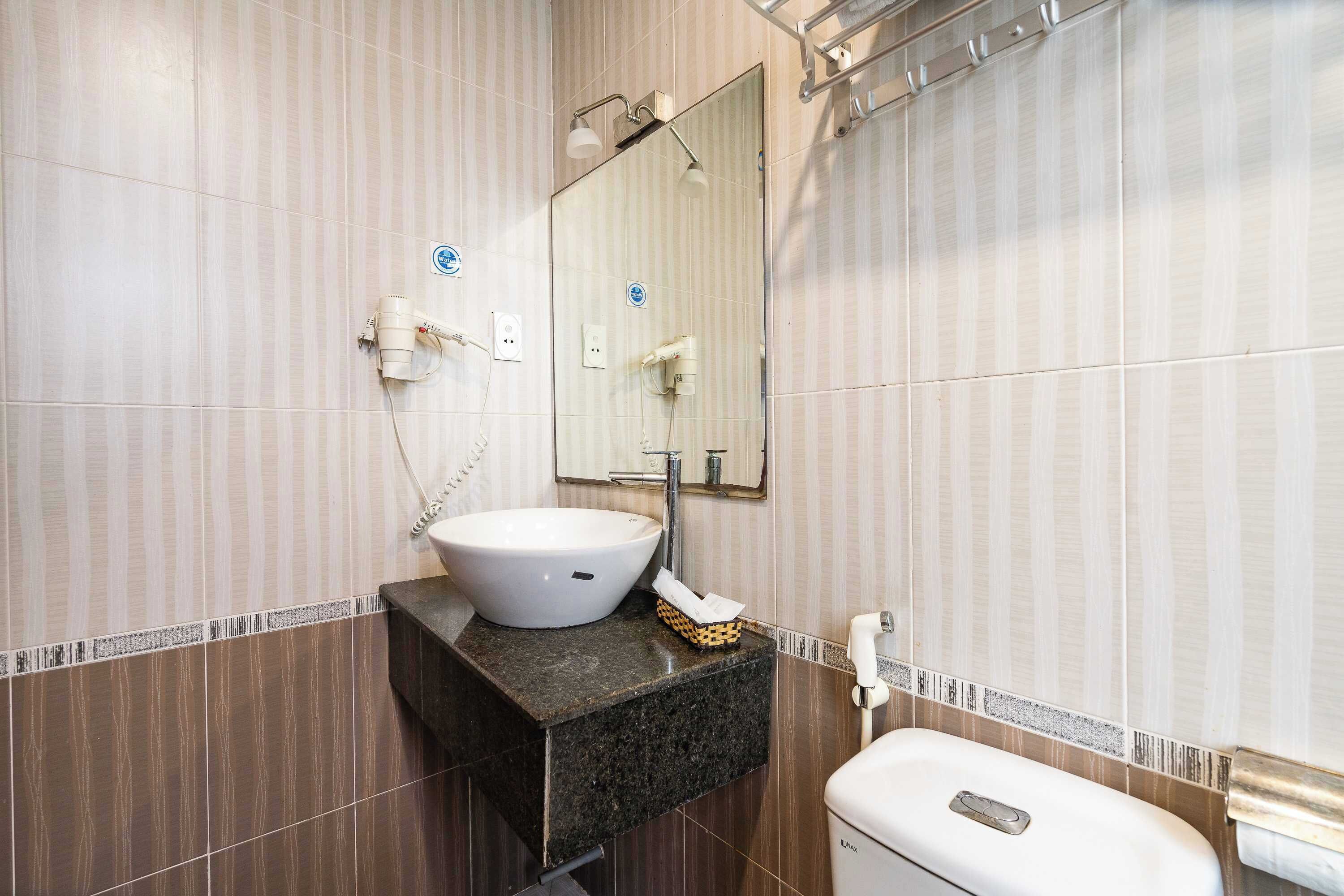 Une salle de bain avec un lavabo, un miroir et des toilettes.