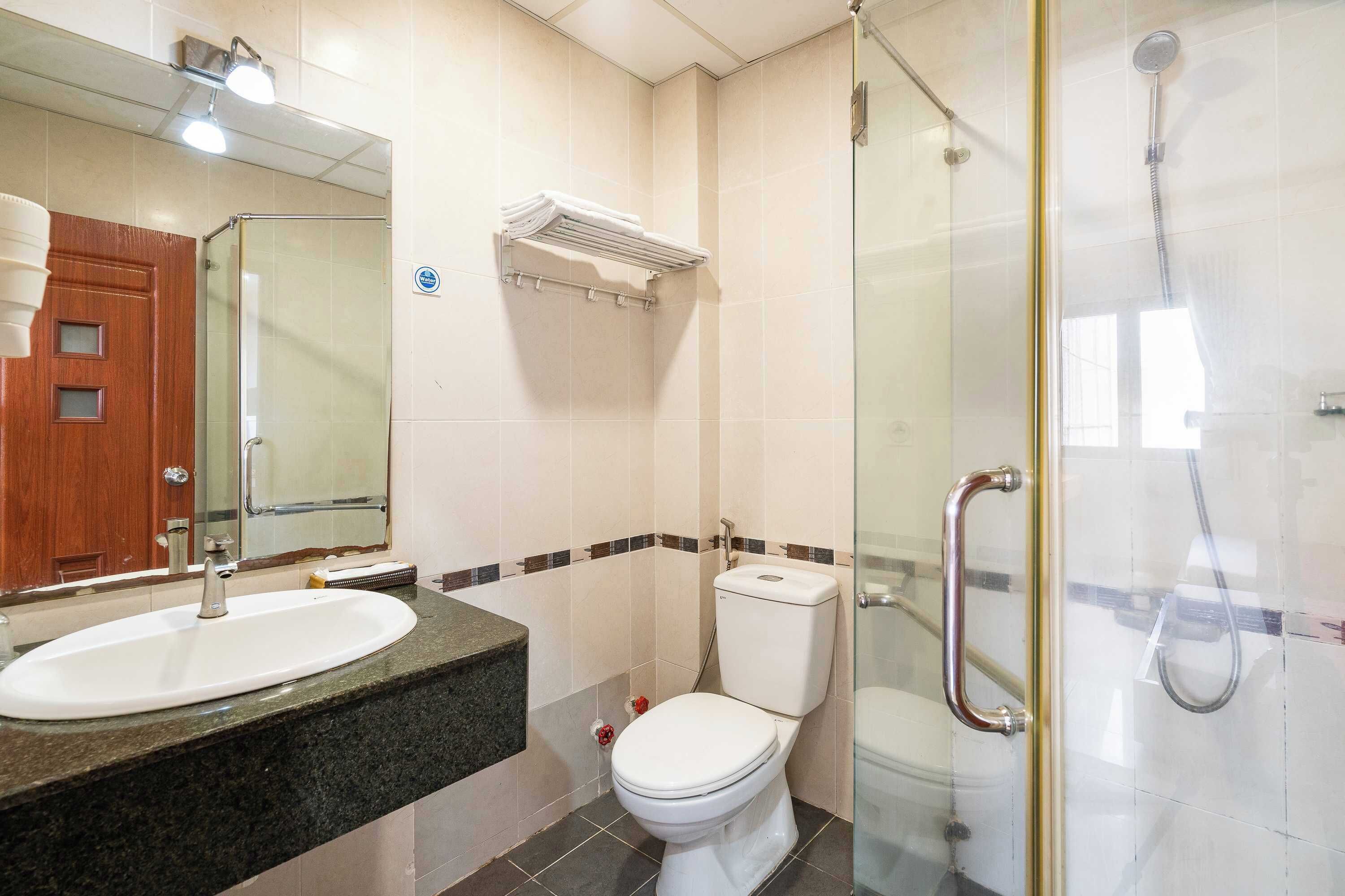 A bathroom with a sink, toilet, and glass-enclosed shower.