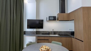 Una cocina moderna con televisión de pantalla plana, microondas y pileta.